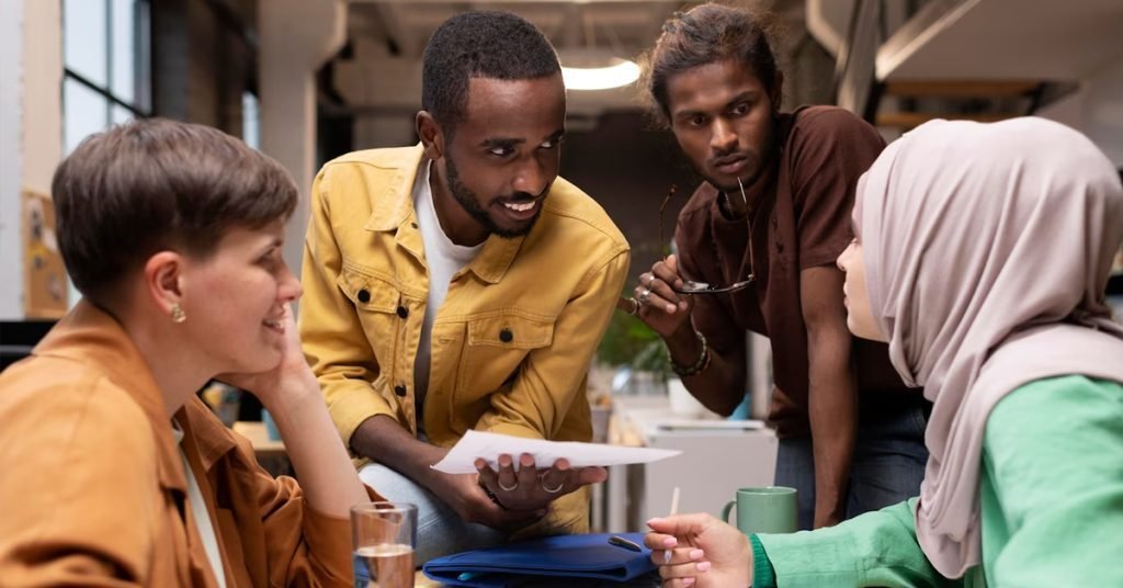 a group of people sitting around a table and having a conversation