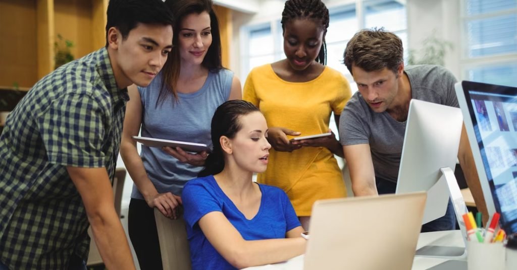 a group of people looking at the computer