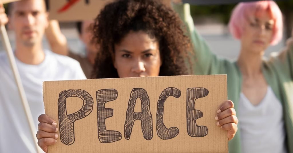 a woman holding a sign written peace