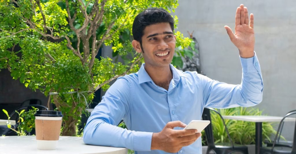 a man holding a phone and raising his hand