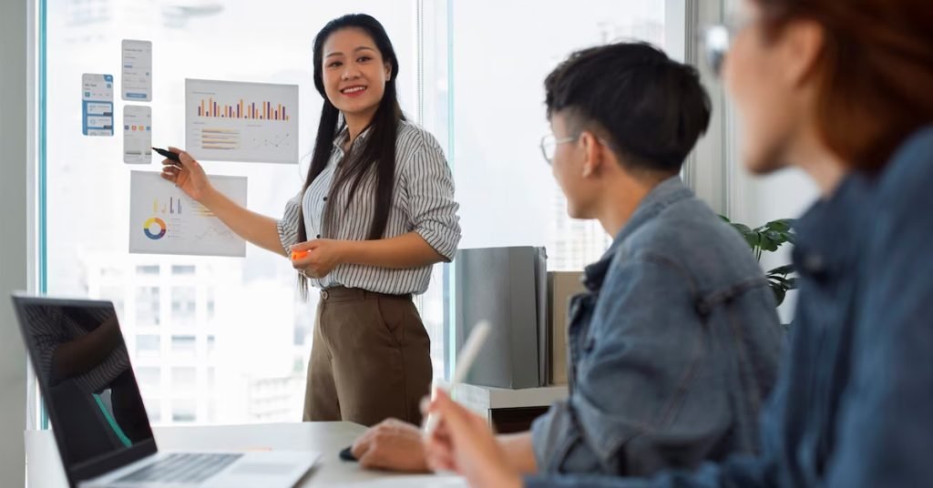 a woman pointing at a whiteboard