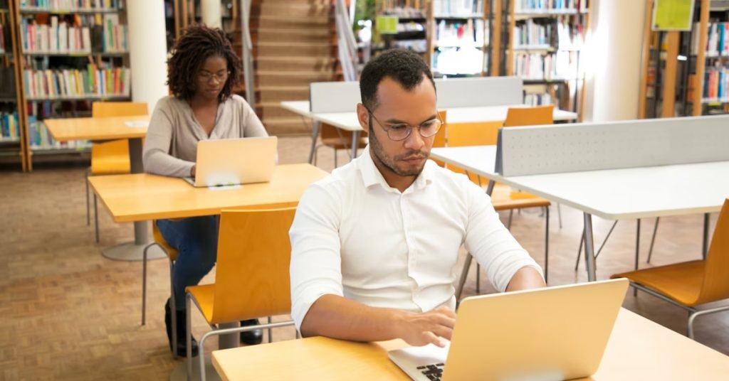 a man and woman sitting at desks with laptops