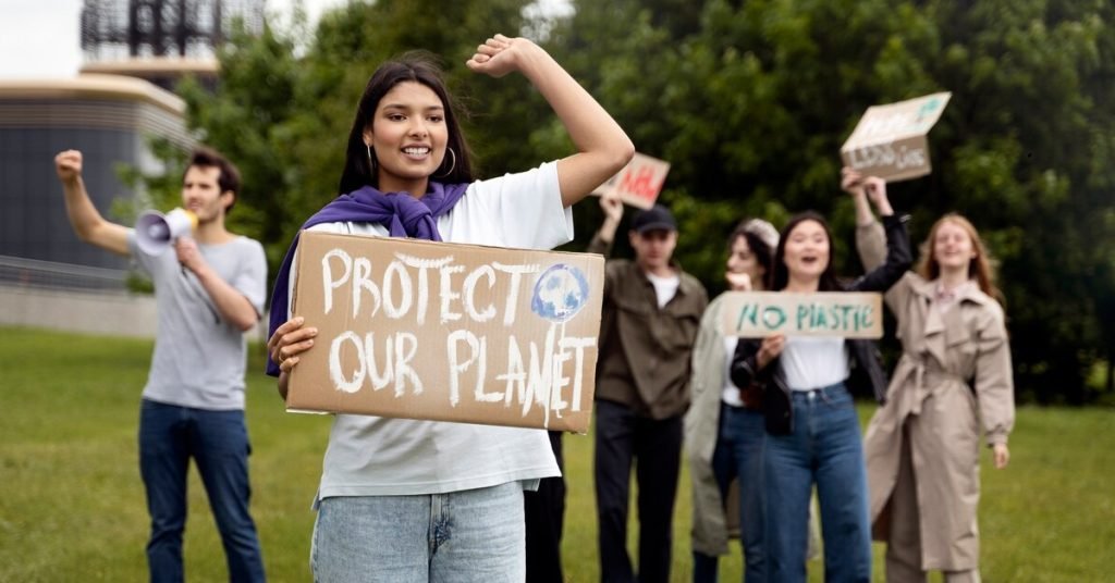 a group of people holding signs to protect our planet