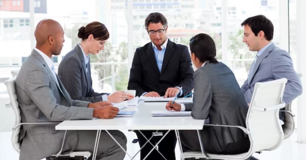 a group of people sitting at a table and having a professional conversation