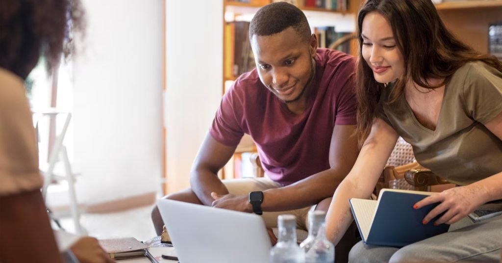 a man and woman looking at a laptop