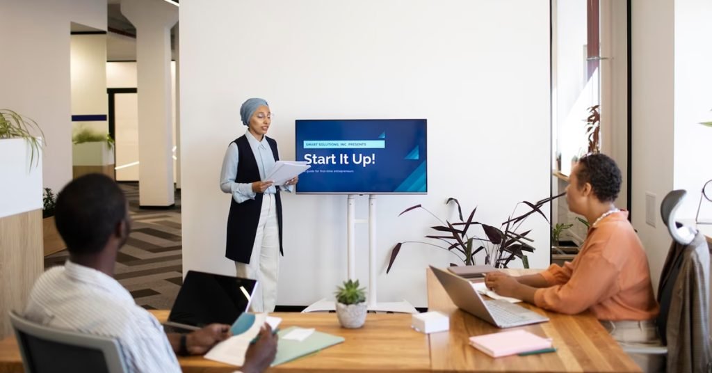 a woman standing in front of a screen in a meeting