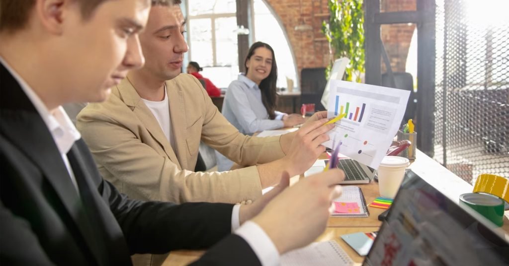 a group of people sitting at a table looking at a graph