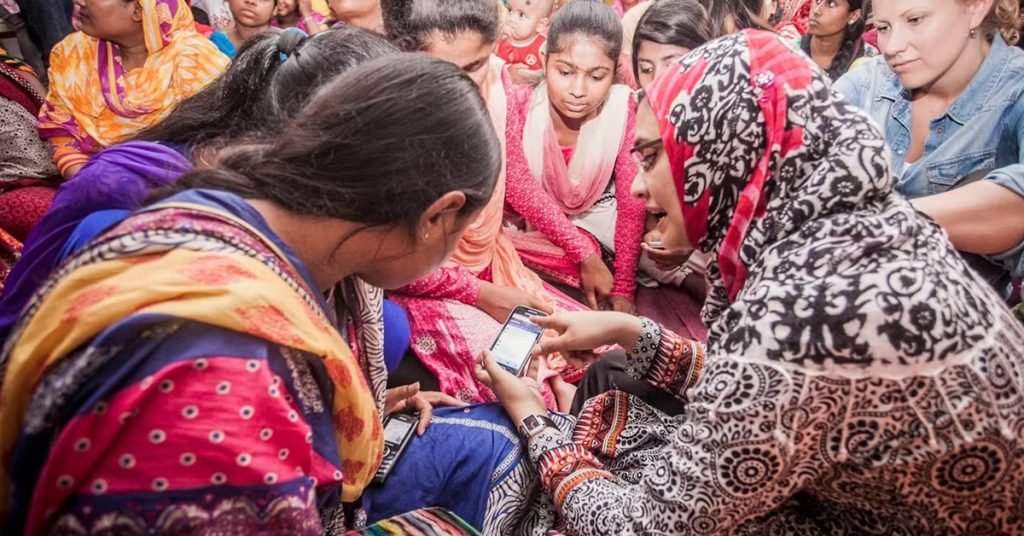 a group of women looking at a cell phone