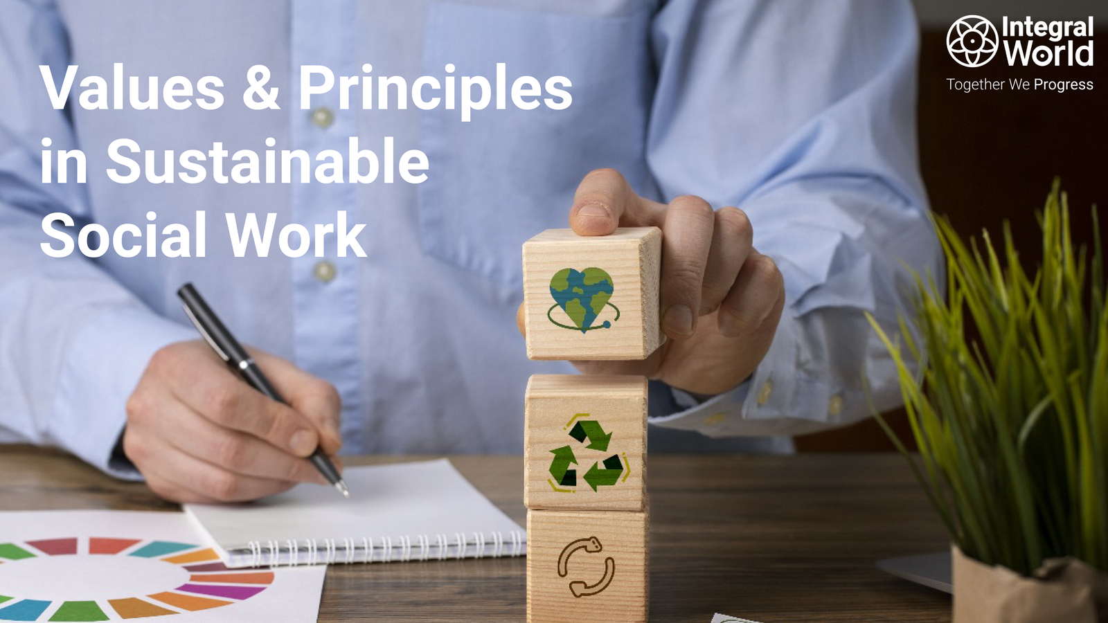 a man with wooden squares writing on paper signifying Values & Principles in Sustainable Social Work